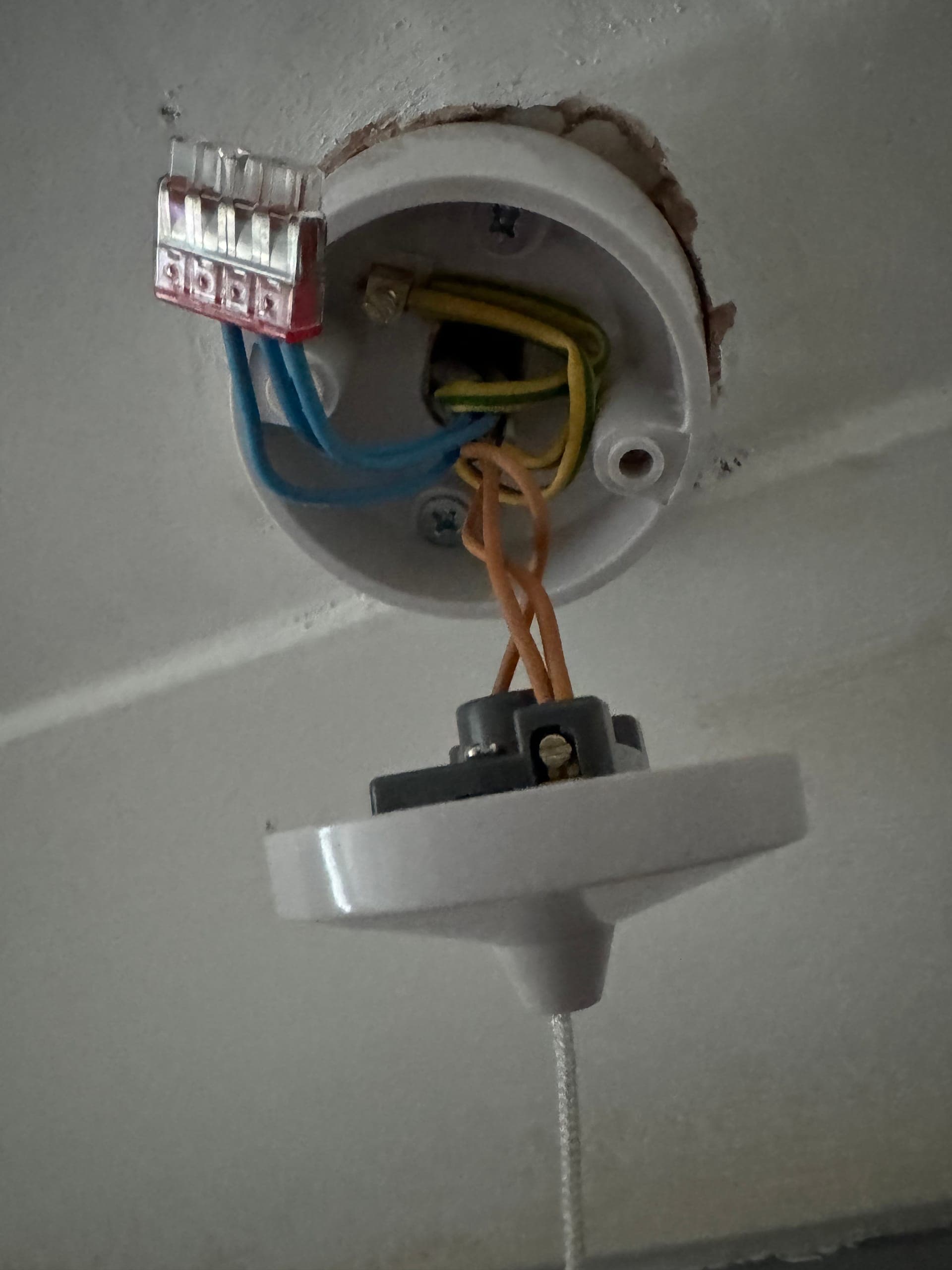 Ceiling-mounted pull-cord switch opened up, wired through a push-fit connector block
