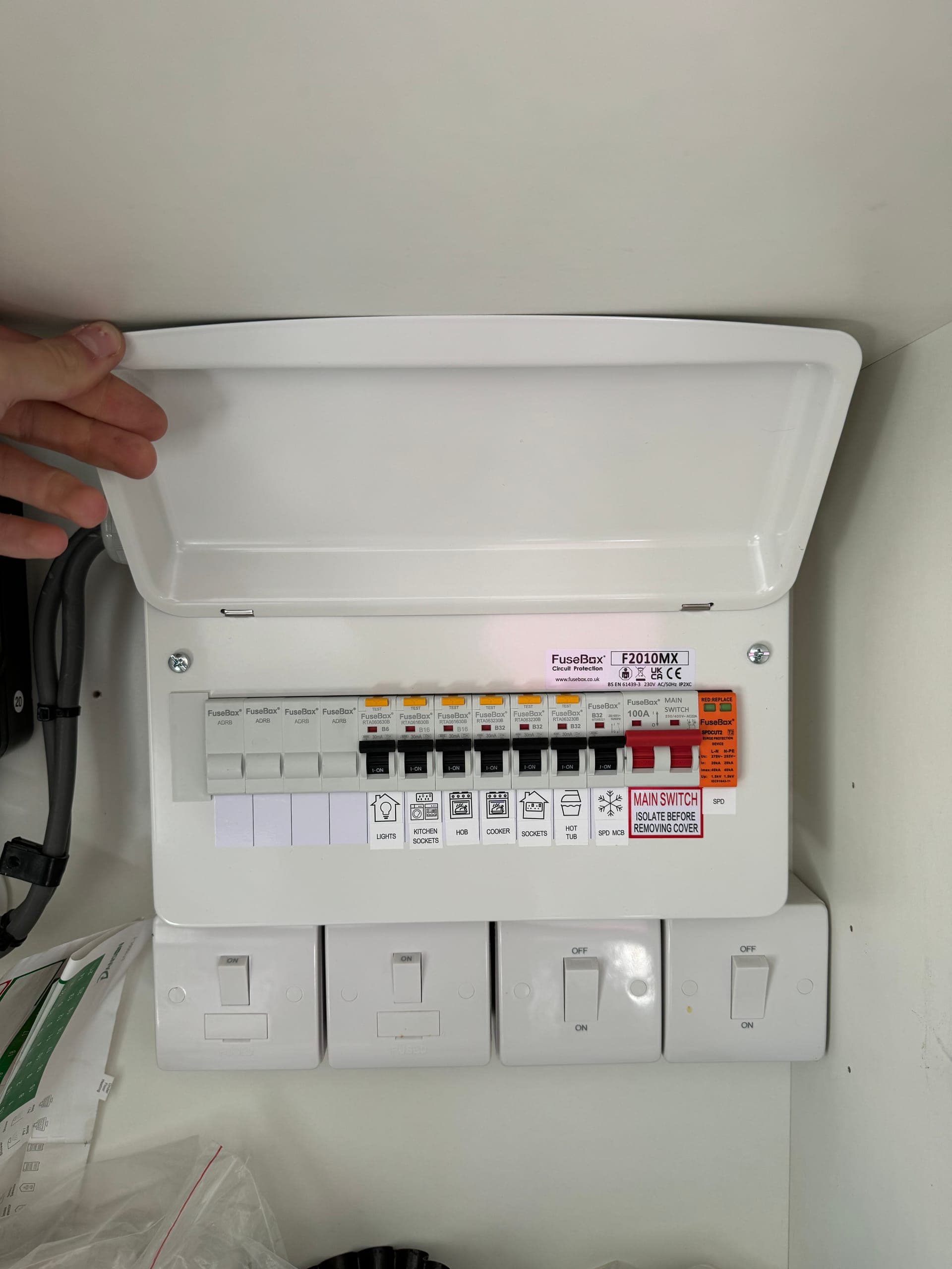 FuseBox consumer unit with the lid open, every circuit labelled from lights and kitchen sockets through to the hot tub