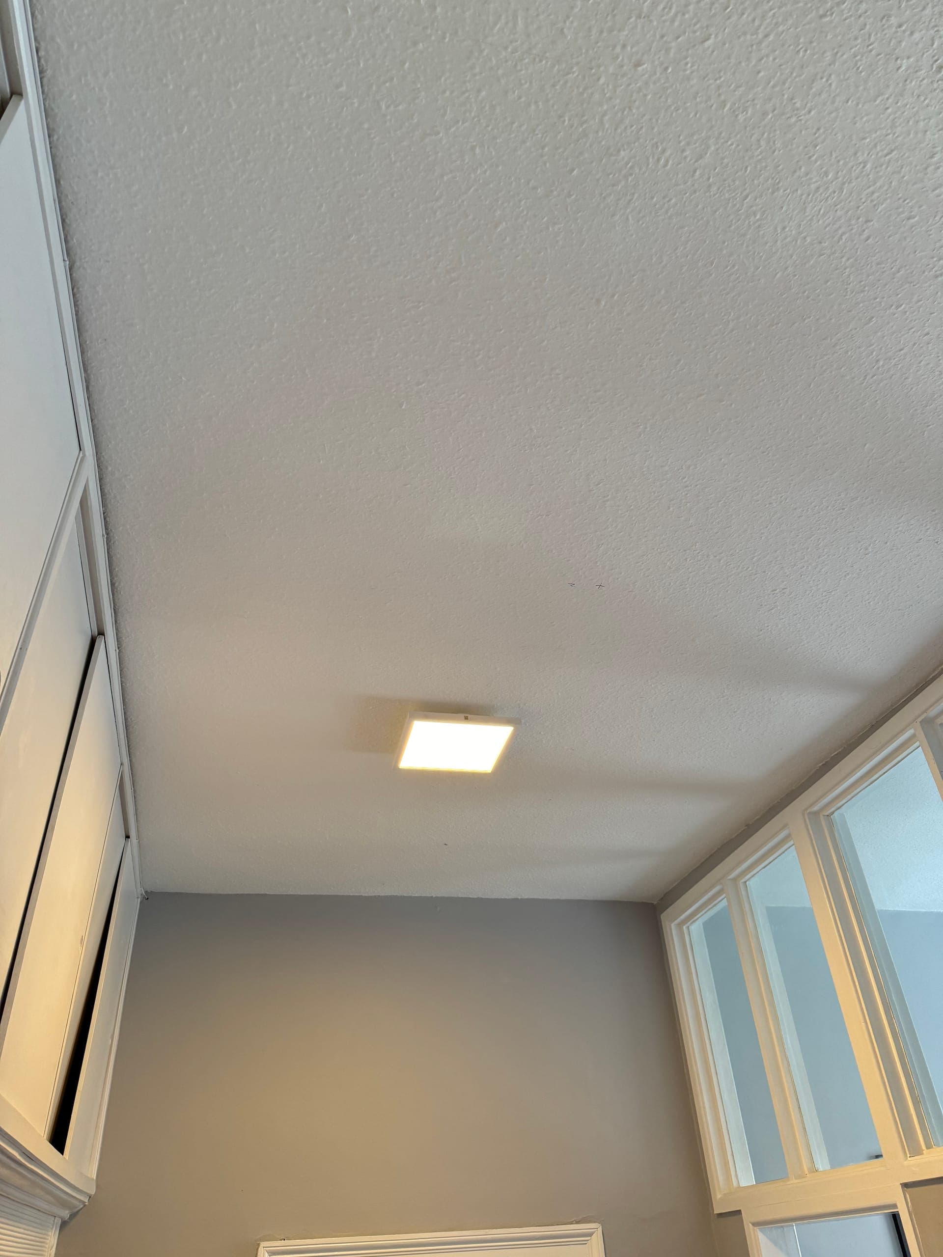 Square LED panel light fitted to a landing ceiling