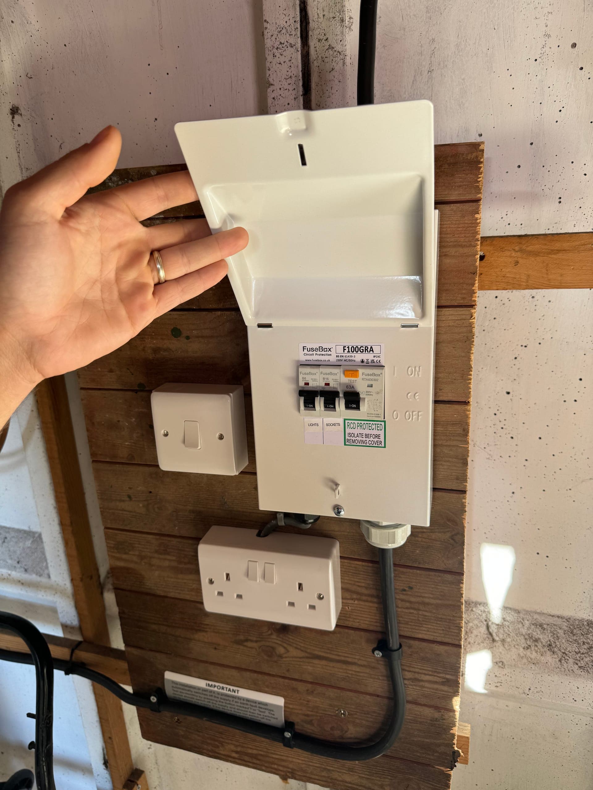 Compact garage consumer unit with separate lights and sockets circuits on RCD protection, mounted on boarding