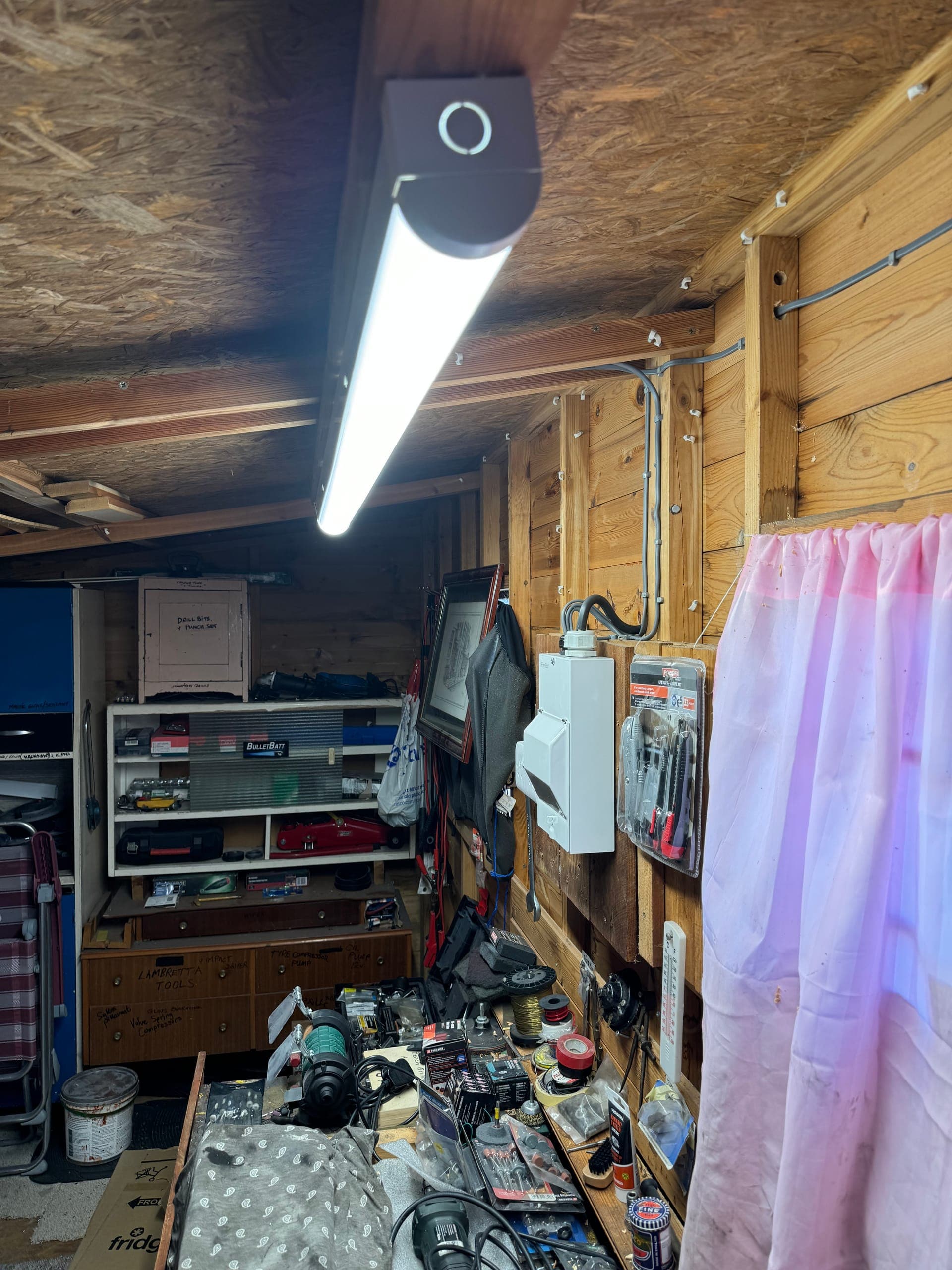 LED batten light lighting a timber workshop, with an isolator switch on the wall