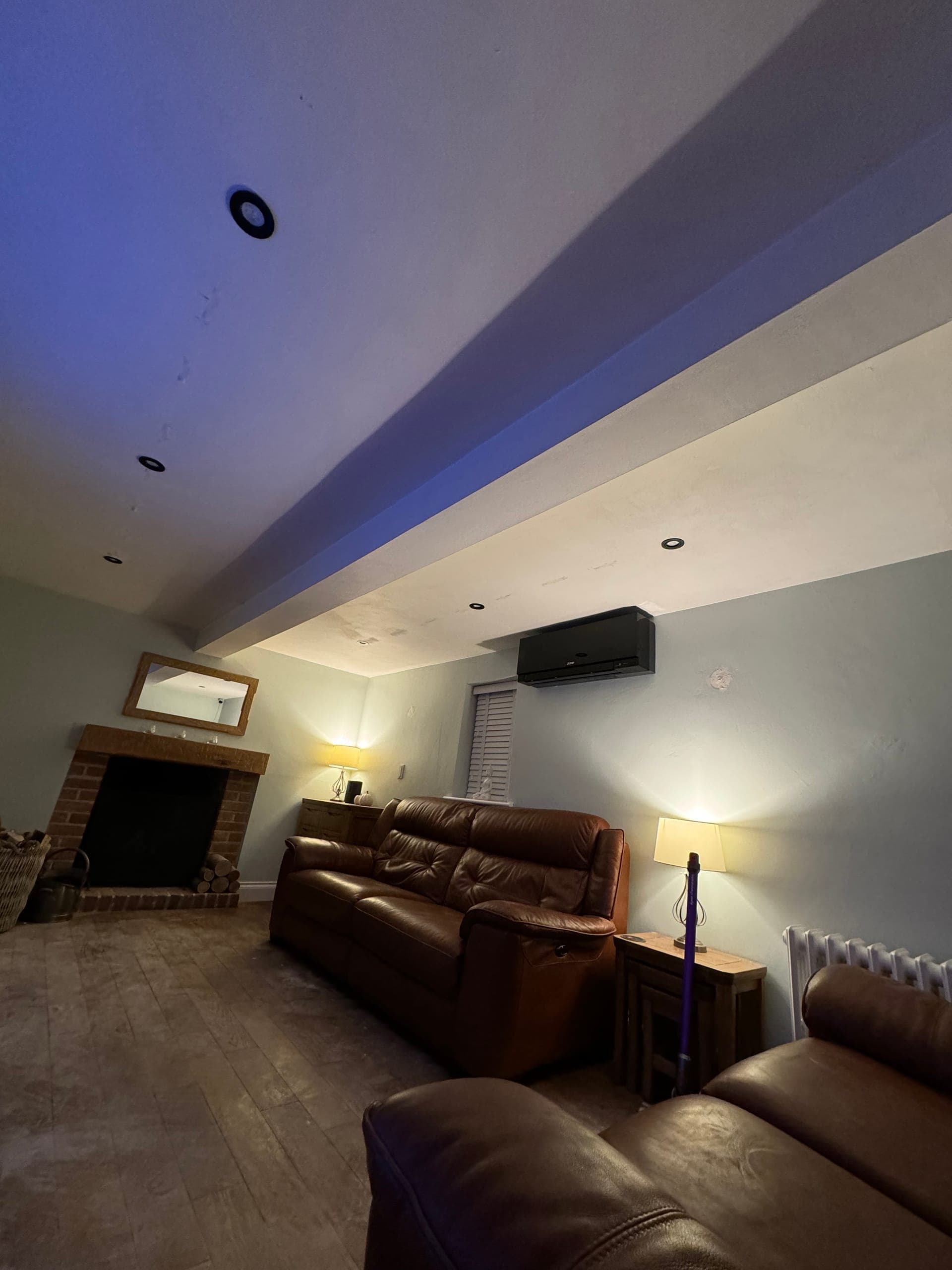 Living room with recessed downlights and colour-changing cove lighting concealed in a dropped ceiling